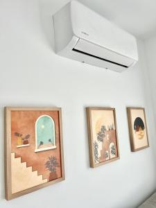 贝莱斯PISO EN EL CENTRO DE VELEZ MALAGA的墙上有三幅画,配有吊扇