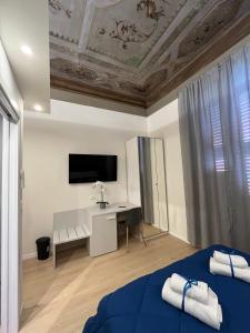 博洛尼亚La Suite Deluxe Rooms & Apartments的一间卧室配有一张床、一张书桌和一台电视。
