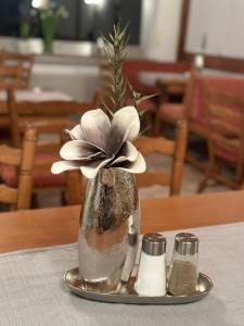 特赖斯-卡尔登Mike‘s Mosel Lodge的花瓶,花在桌子上的盘子上