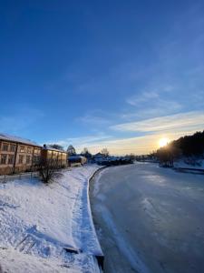 波尔沃Rune Bergin piilopaikka的一条雪覆盖着,有太阳背景的道路