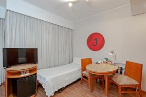 圣保罗Slaviero São Paulo Moema的客房设有1张床、1张桌子和1台电视。