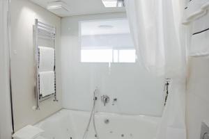 莫尔科泰"Fall in love only" Morcote lake的白色的浴室设有浴缸和镜子