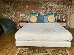 NoduwezLa Cure de Noduwez的一间卧室设有一张带砖墙的大床