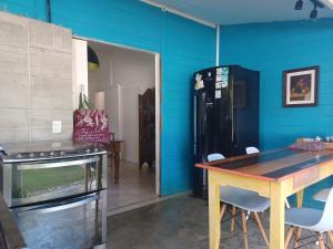 阿拉卡茹Vila Eco SPA的厨房拥有蓝色的墙壁、桌子和冰箱