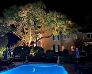 维克斯堡Anchuca Historic Mansion & Inn的夜间在房子前面的游泳池