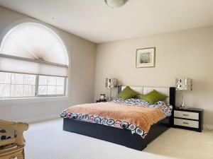 温哥华SUMMER HOME的一间卧室设有一张床和一个拱形窗户