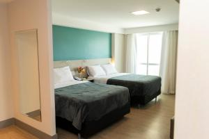 累西腓202 Flat Beira Mar Av Boa Viagem com Cozinha的酒店客房,设有两张床和镜子