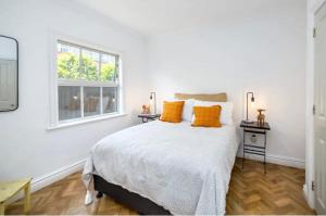 格雷敦Karoo House的一间卧室配有带橙色枕头的床和窗户。