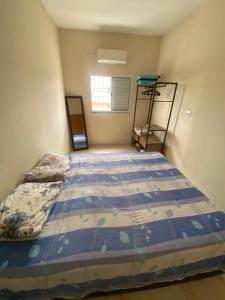 瓜拉廷格塔Apartamento Bela vista II的一间卧室配有一张带蓝色棉被的床