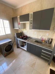 瓜拉廷格塔Apartamento Bela vista II的厨房配有水槽和洗衣机