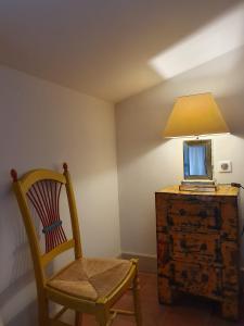 于泽斯La petite hostellerie的一个带椅子和梳妆台灯的房间