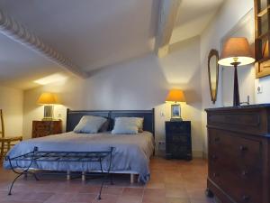 于泽斯La petite hostellerie的一间卧室配有一张大床和一个梳妆台