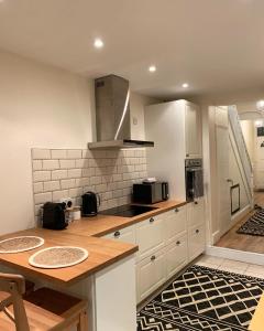 卡迪夫Cardiff Home的厨房配有白色橱柜和木制台面