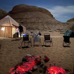 Az ZabūEgypt Desert Tours的沙漠中的一组椅子和帐篷