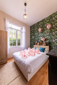 鲁昂Suite Amazonia ~ Balnéo ~ Arrivée Autonome的一间卧室配有一张粉色猪床。