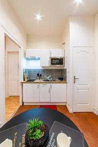 鲁昂Suite Amazonia ~ Balnéo ~ Arrivée Autonome的厨房配有白色橱柜和桌子