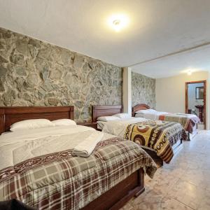 昆卡Quinta San Martín的一间卧室设有两张床和石墙