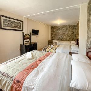 昆卡Quinta San Martín的一间带两张床的卧室和一台电视