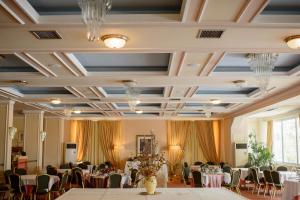 莱瓦贾Hotel Philippos Livadeia的宴会厅配有桌椅和吊灯