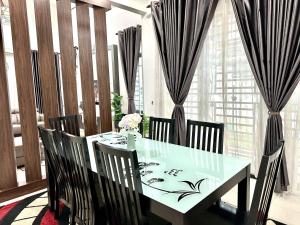 马六甲Bandar Melaka Family Bungalow Private Pool BBQ WiFi Netflix的一间带桌椅和窗帘的用餐室