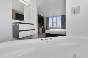 霍巴特Allurity Hotel的白色的浴室设有床和镜子