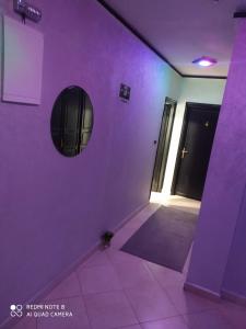 贝尼迈拉勒Hotel La coline的紫色的房间,设有门和镜子