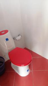 VillanuevaVilla Myrian的浴室里红色的厕所和红色的盖子