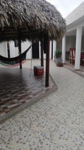 VillanuevaVilla Myrian的一个带吊床和稻草伞的度假胜地