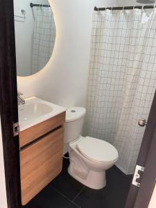 布兰卡滩SUNSET BEACH的一间带卫生间、水槽和镜子的浴室