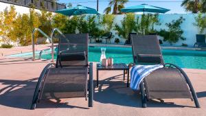 沙漠温泉Onsen Hotel and Spa的游泳池畔的一张桌子和两把椅子