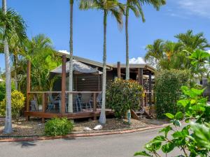 赫维湾船港一室公寓公寓式酒店和别墅的前面有棕榈树的房子