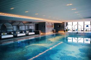 苏州苏州古运河英迪格酒店的一个带酒店客房床铺的大型游泳池