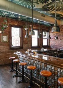 威尔明顿ARRIVE Wilmington的一间酒吧,里面设有棕色的凳子和砖墙