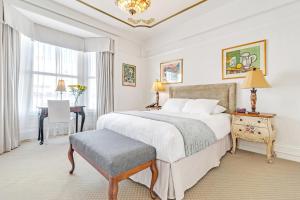 旧金山法兰西康奈尔酒店的卧室配有一张白色大床和一张书桌