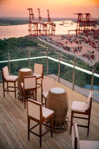 仰光The Rangoon Hotel的一个带桌椅的海景甲板