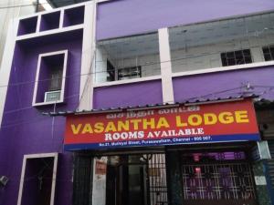 钦奈Vasantha Lodge Purasawalkam chennai的紫色的建筑,上面有读过时尚小屋的标志