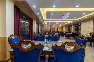 柴尔Sterling Shivalik Chail的一间带长桌和蓝色椅子的用餐室