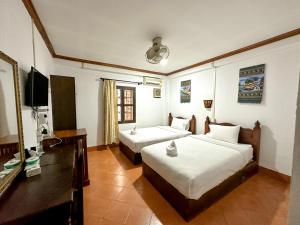 琅勃拉邦Chaliya Boutique Garden的酒店客房设有两张床和电视。