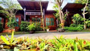 Ban Chong PhliAreeya phubeach resort wooden house的前面有一堆植物的房子