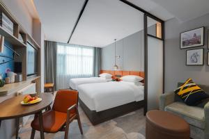 武汉武汉汉口火车站希尔顿惠庭酒店的酒店客房设有两张床和一张桌子。