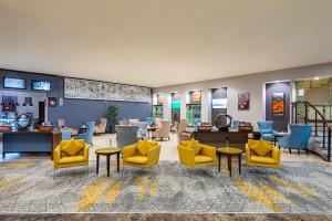 利雅德利雅得圣堡假日酒店的一间设有黄色椅子和桌子的等候室