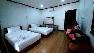 万荣Vang Vieng Eco Lodge的一间设有两张床的房间,里面种着鲜花