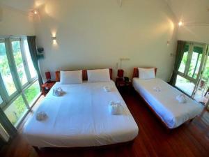 万荣Vang Vieng Eco Lodge的带大窗户的客房内的两张床