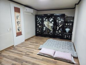 庆州纳姆阿旅馆的一间位于地板上的客房,配有一张床和两个枕头