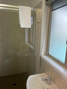 穆卢拉巴凯亚玛汽车旅馆的一间带水槽和淋浴及窗户的浴室