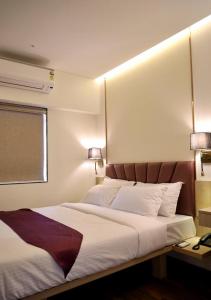 孟买Vishal Hall的一间卧室配有一张带两盏灯的大型白色床。