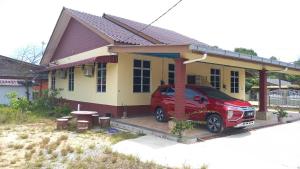 Kampong Wakaf TengahMufeed Homestay的停在房子前面的红色汽车