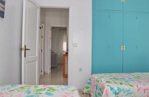 科尼尔-德拉弗龙特拉Apartamento La Fuente的一间设有两张床的客房和通往走廊的门