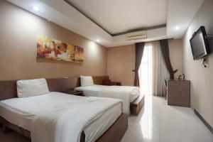当格浪Safwah Bintaro Syariah Mitra RedDoorz的一间酒店客房,设有两张床和电视