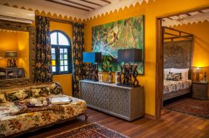 桑给巴尔科勒酒店的一间卧室设有黄色的墙壁和大镜子